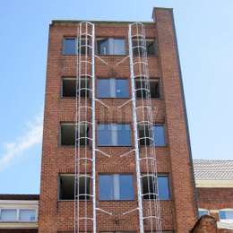 Window fire escape cage ladder 2 cage ladders placed perpendicular to the facade, next to windows and used for the evacuation of a 7 story building.